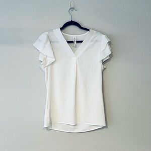 White v-neck medium blouse with ruffled short sleeves.